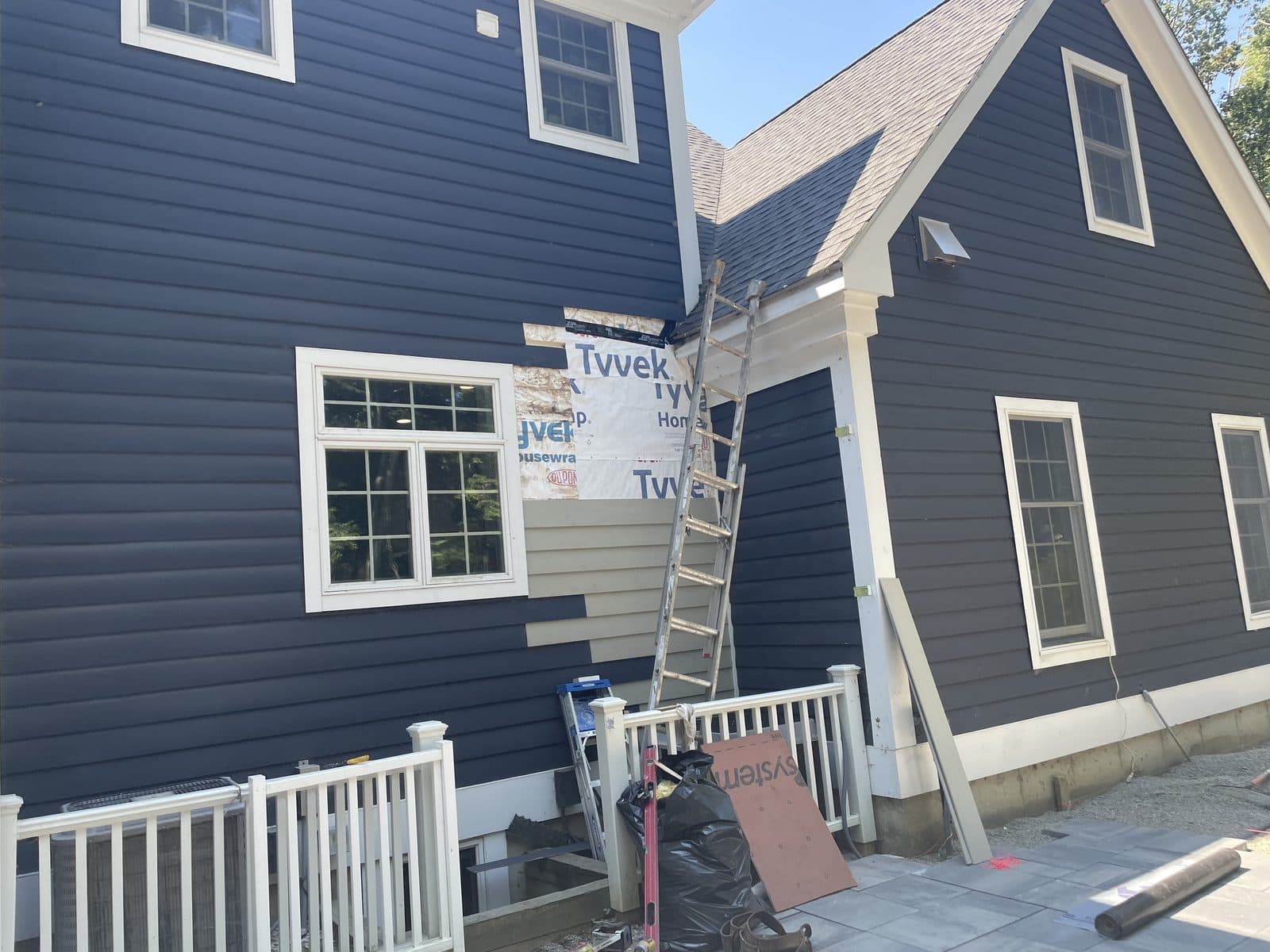 Dark blue sided house with white trim