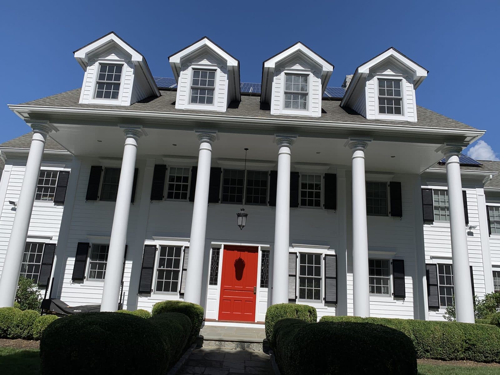 White colonial home with red door