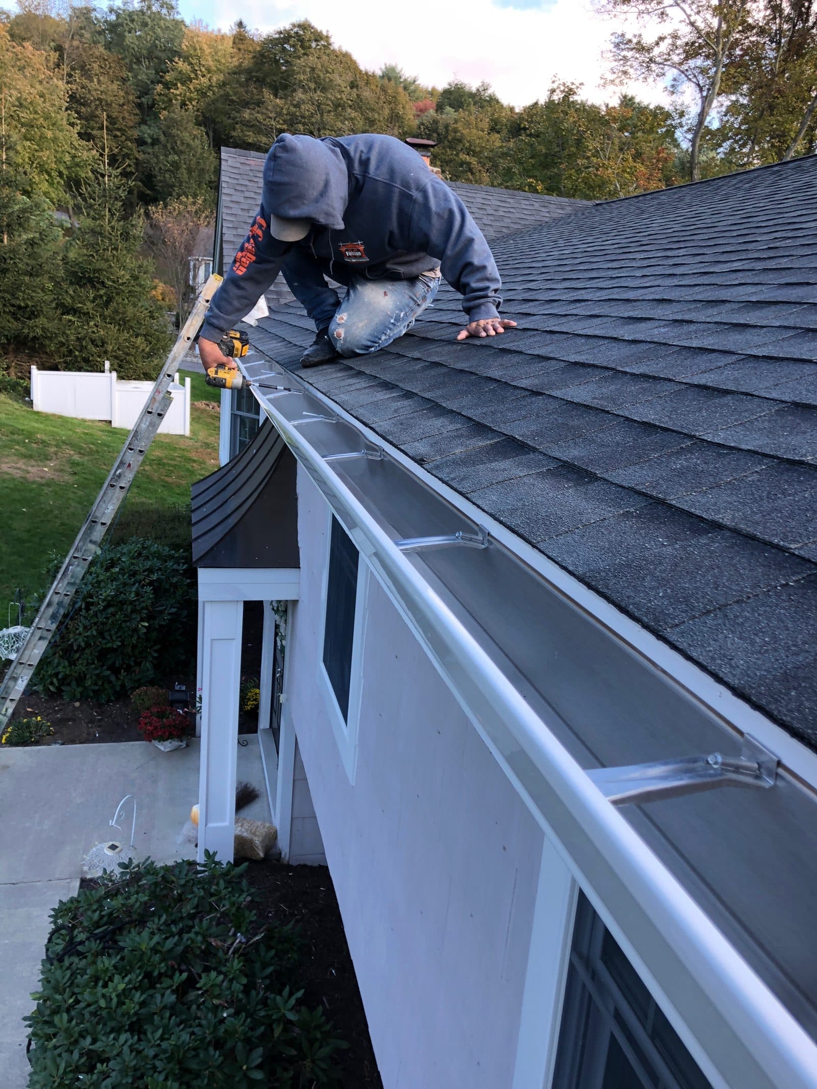 C&C Fabian crew member installing a new gutter along a roof edge.