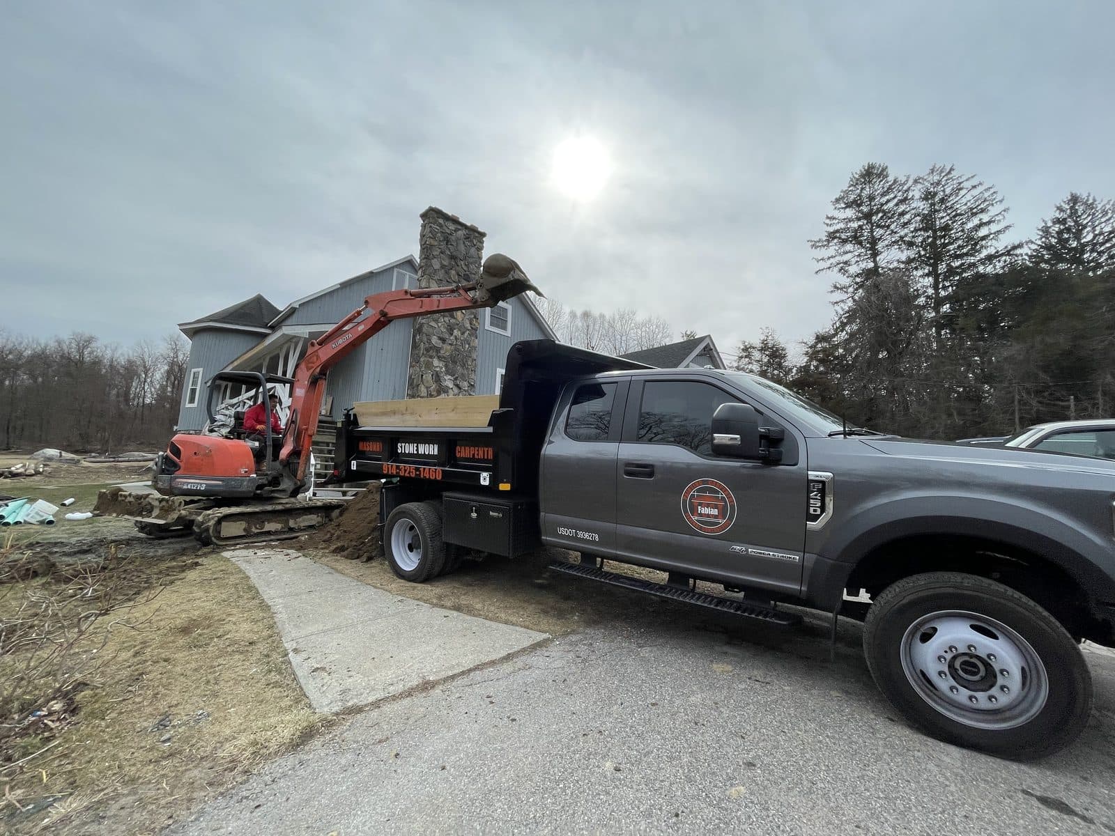 C&C Fabian crew hauling away construction debris with a dump truck.