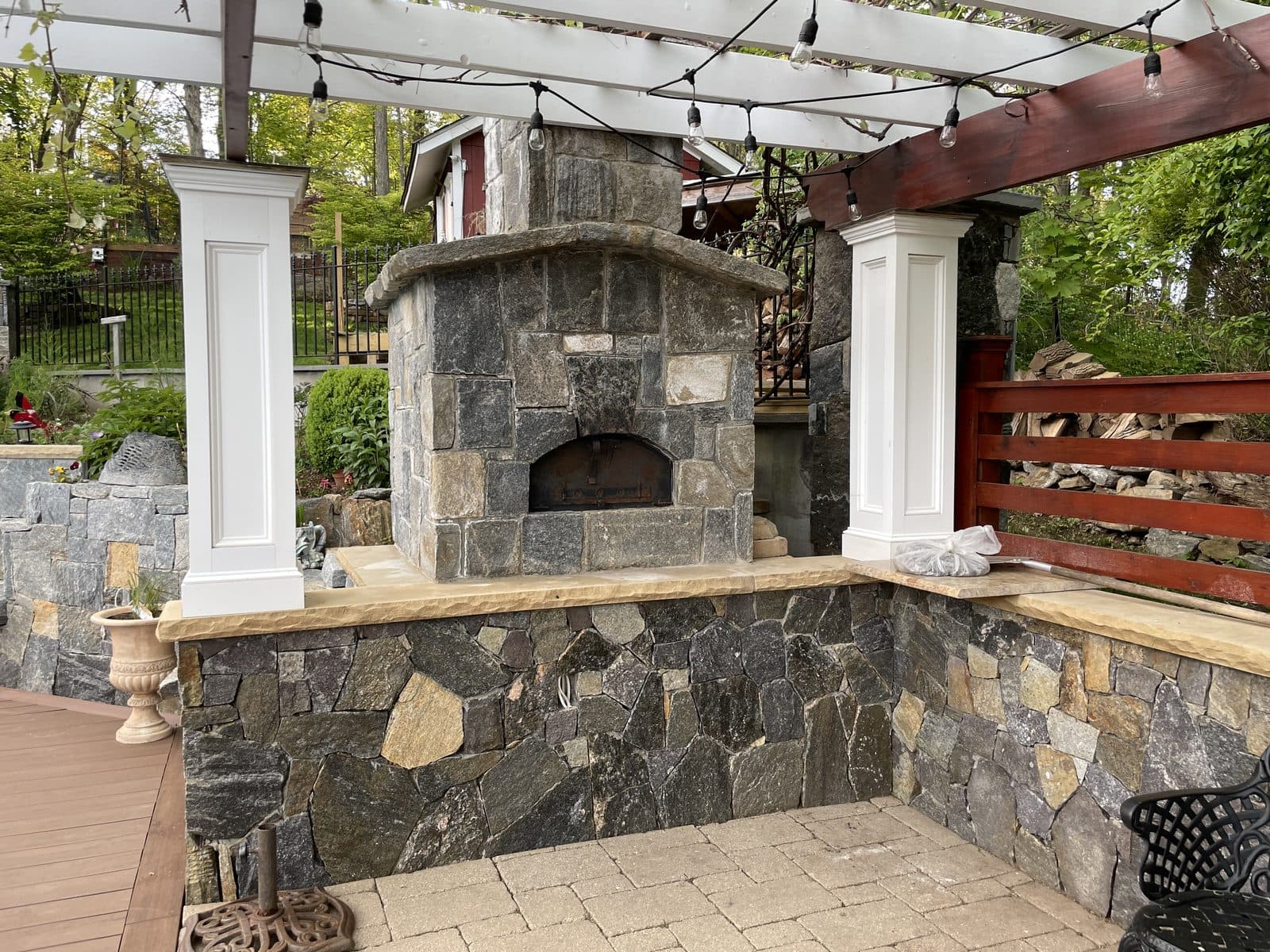 Stone outdoor fireplace with pergola