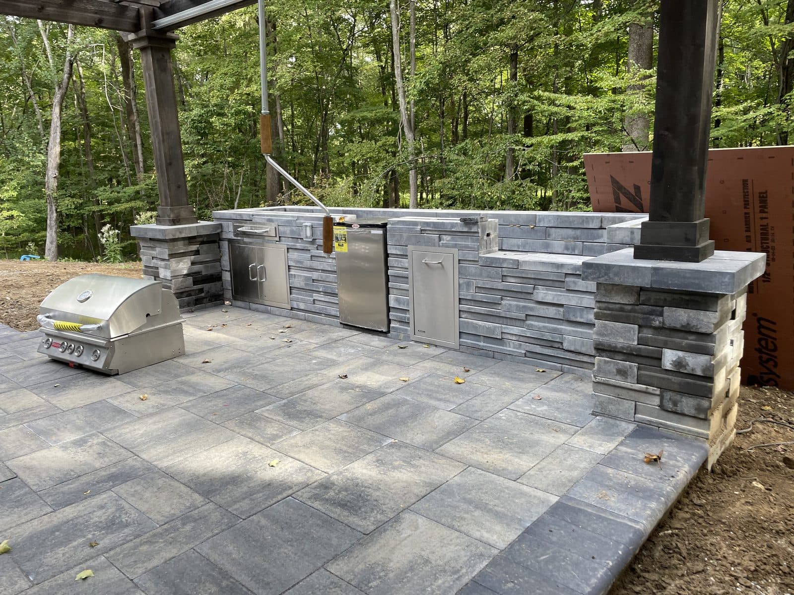 Covered outdoor kitchen with stone patio