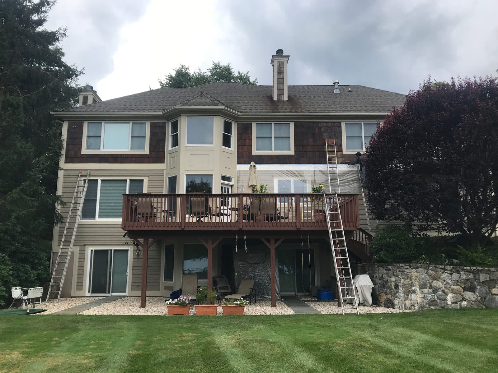 Rear exterior of a lakeside home prepped for power washing