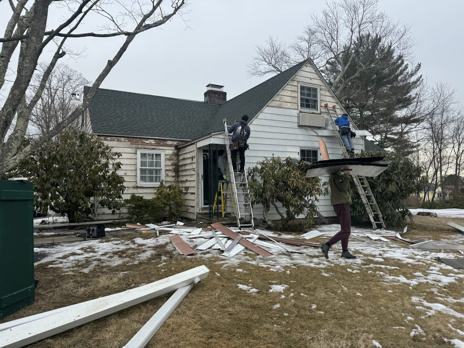 House exterior with snow and worker