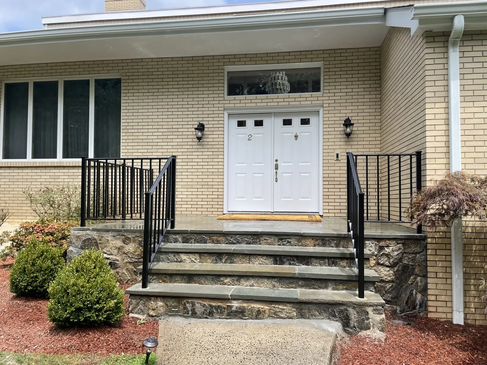 Exterior painting on a white brick columned entry in Yorktown, NY