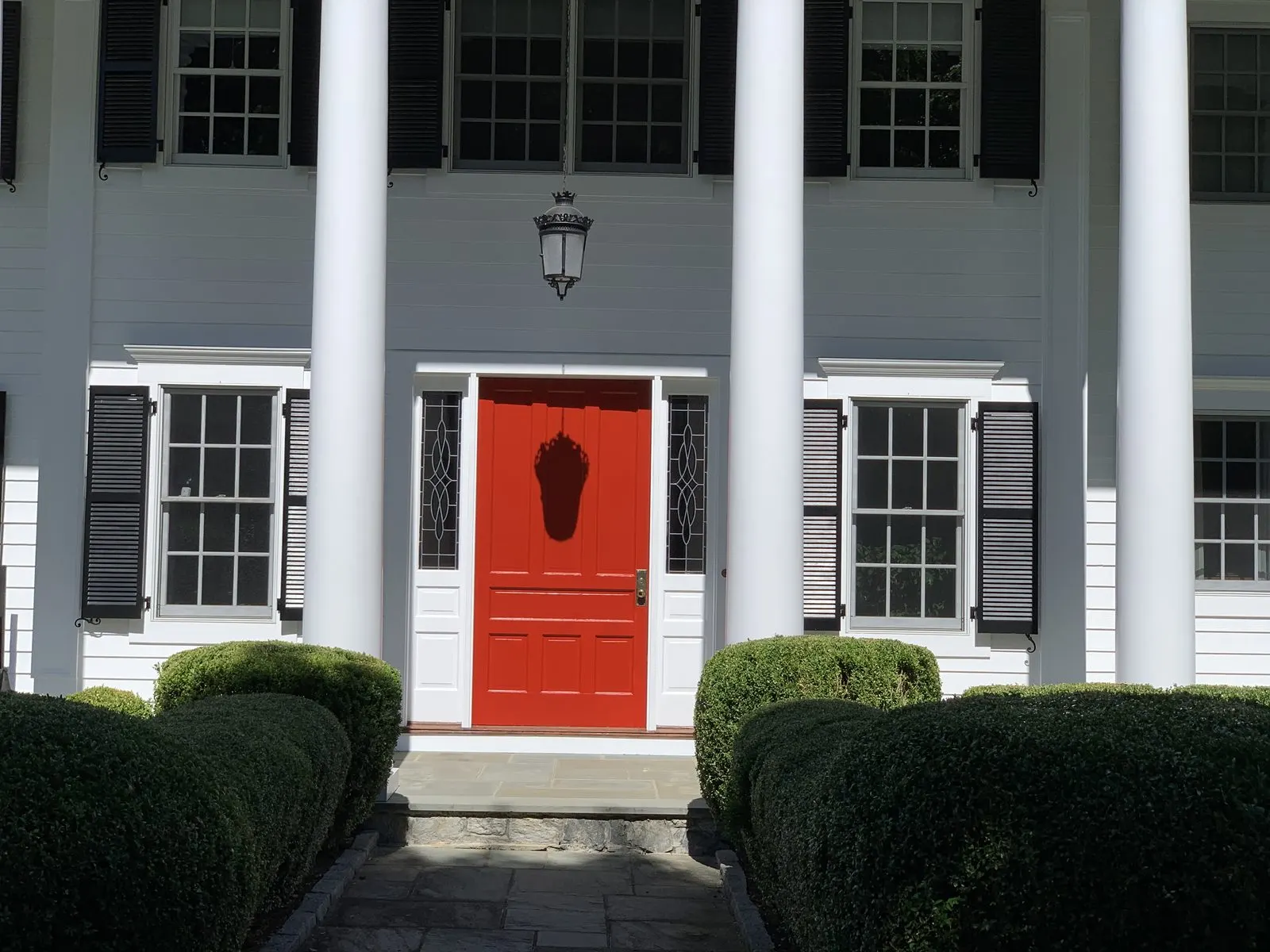 Exterior house painting with a classic red front door in Carmel, NY