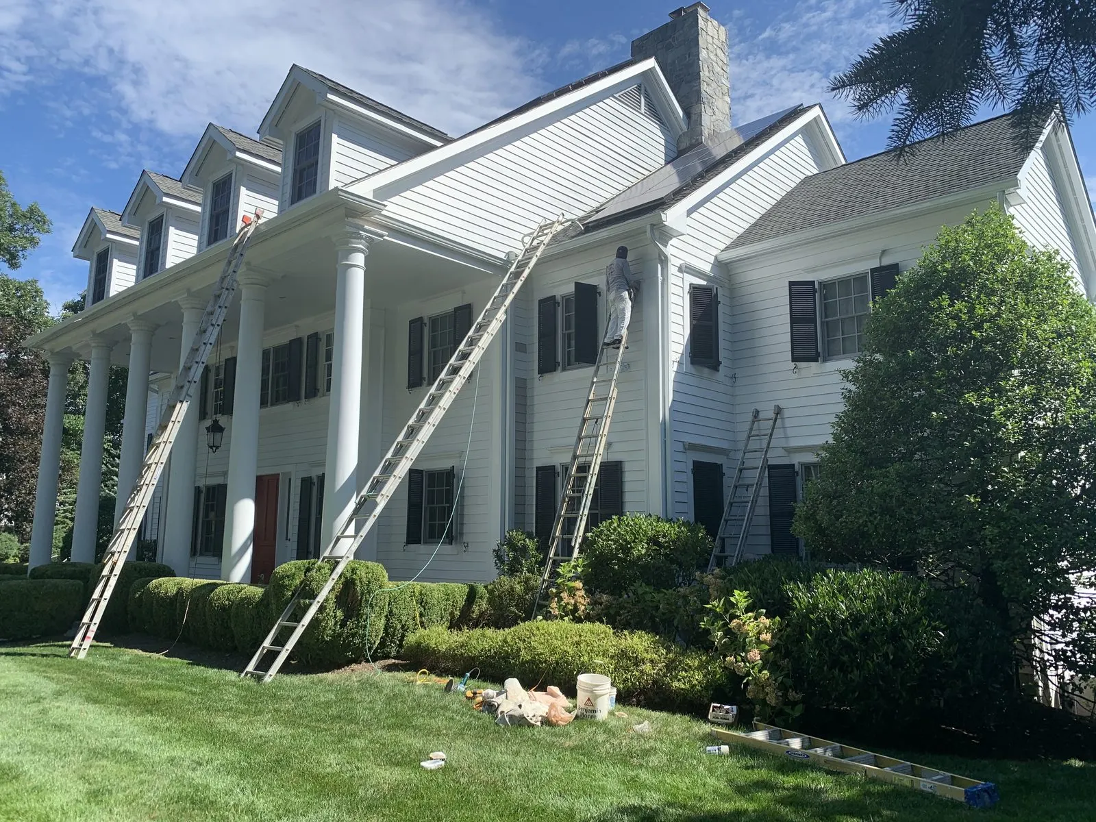 Exterior repaint in progress on a colonial home in Katonah, NY