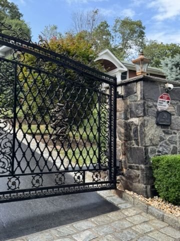 Custom iron double driveway gate with stone columns