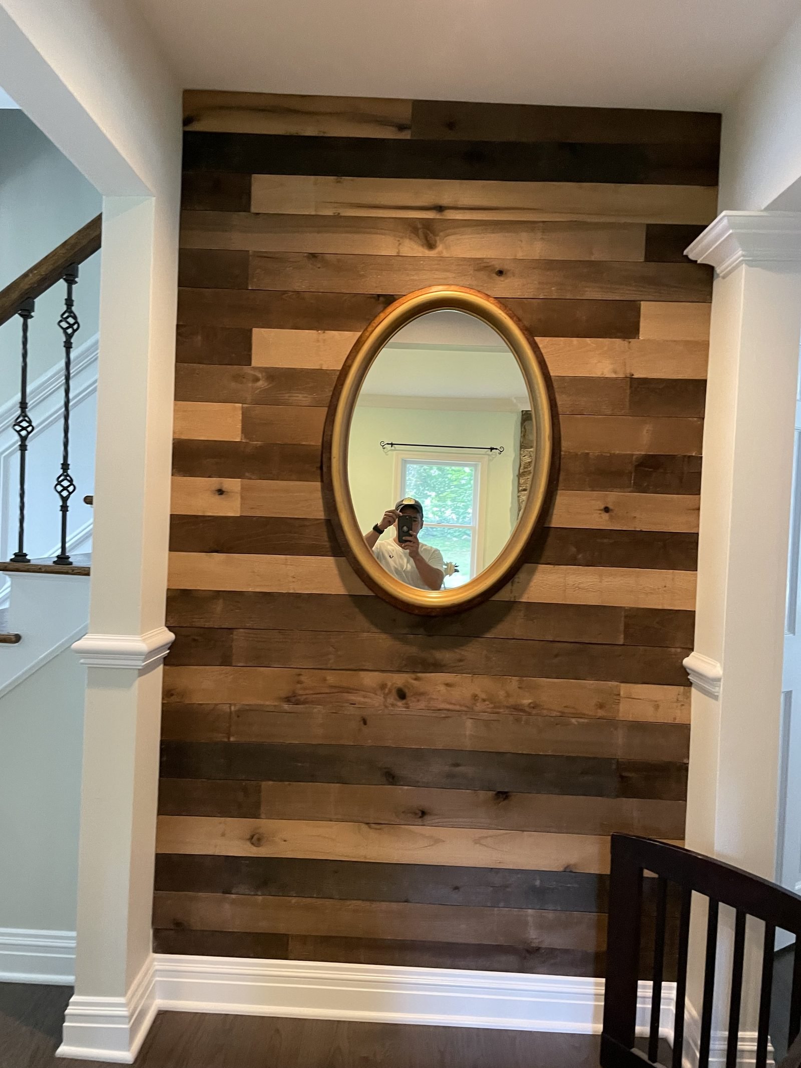 Wood accent wall with round mirror