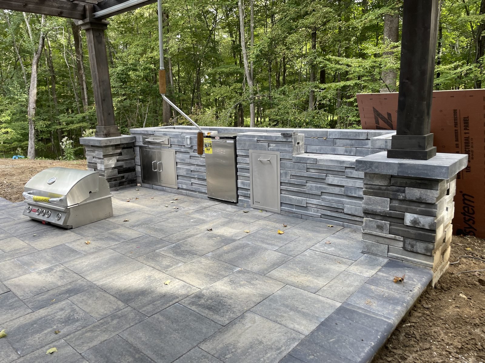 Covered outdoor kitchen with stone patio
